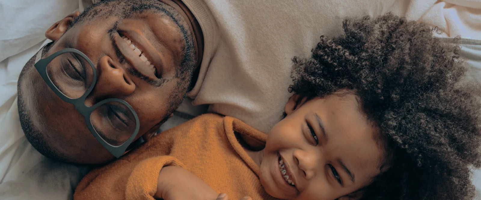 A father and his daughter laughing together at home